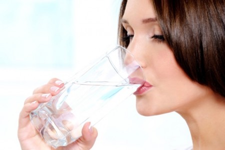 Woman drinks pure water from a glass